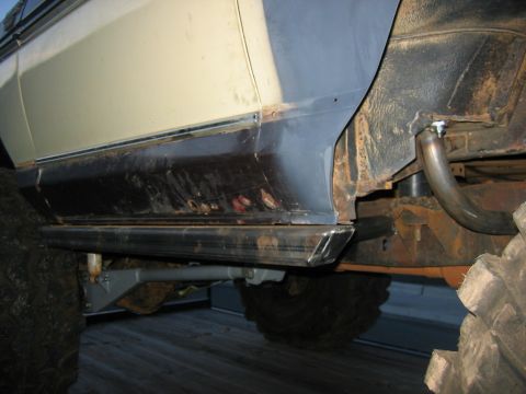 1992 Ford Mustang - Custom rock sliders installed on an off-road vehicle's side, showing rust on the body and frame.