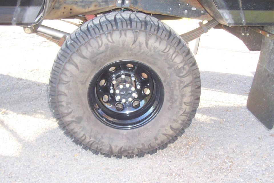 1994 Ford F-150 rear wheel with off-road tire and black rim