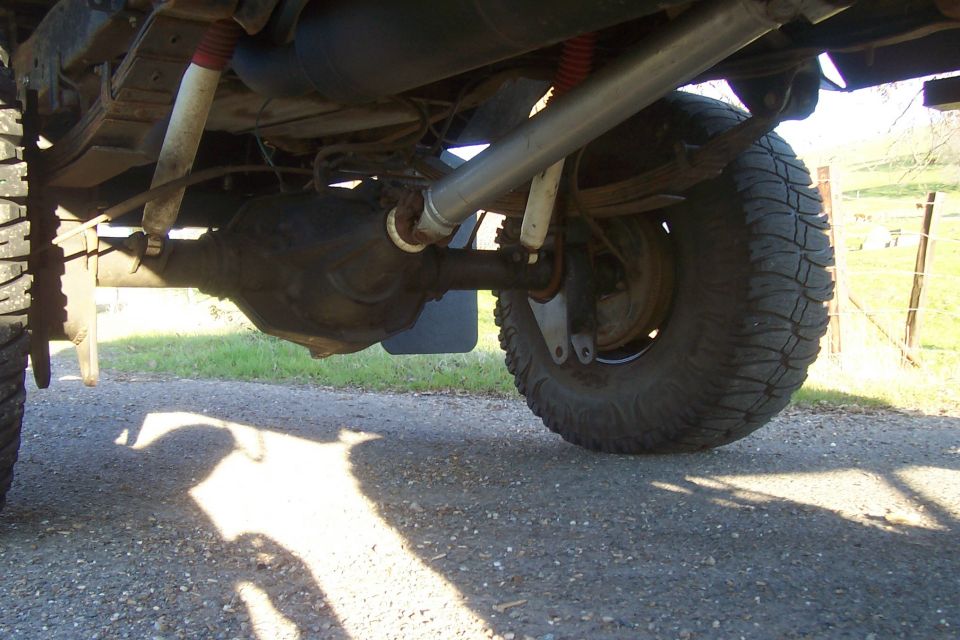 1994 Ford F-150 rear axle with large tires and red-topped shocks