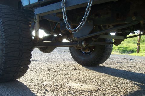 1994 Ford F-150 - Close-up view of a truck's undercarriage, highlighting its heavy-duty suspension and large tires.