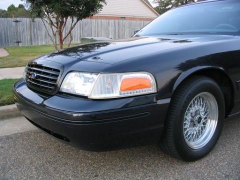 1999 Ford Crown Victoria - Front corner view of a black 1998 Ford Crown Victoria, a chrome grille and distinctive wire wheels.