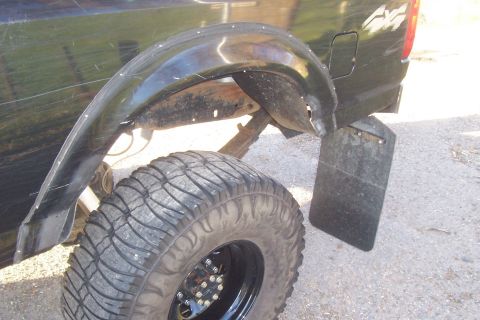 1994 Ford F-150 - Close-up of a truck's rear fender, tire, and mud flap.