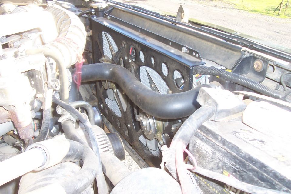 Radiator and fan assembly with hoses and engine components visible
