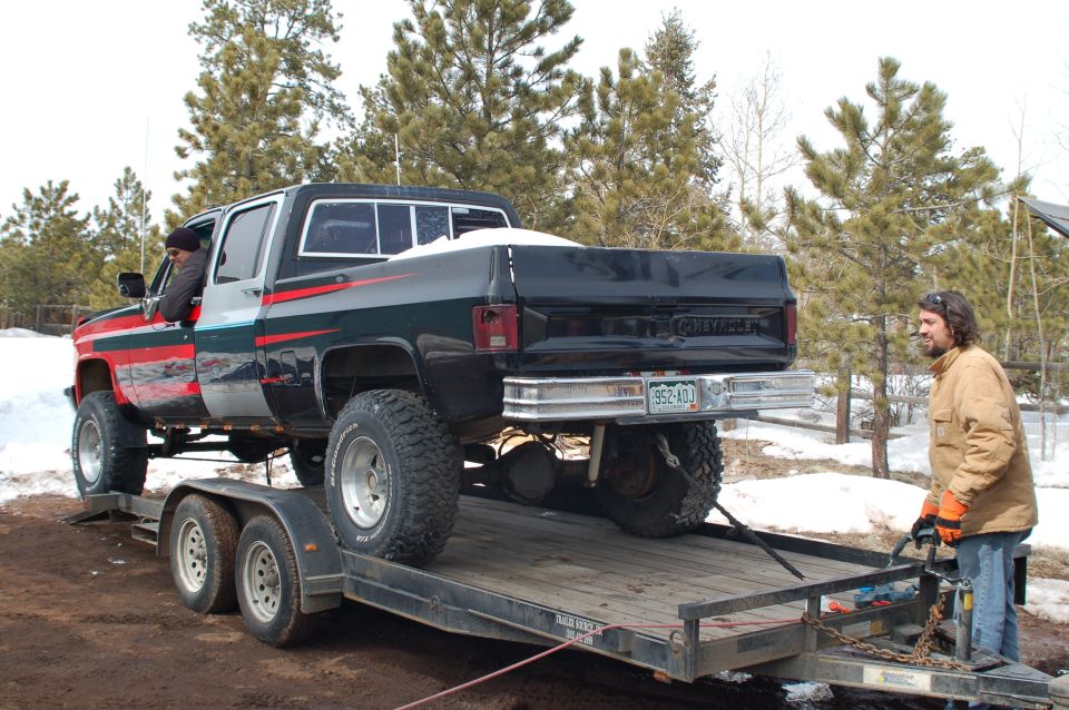 guy loading lifted 1985 Chevrolet C/K Pickup onto trailer
