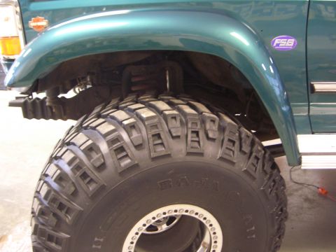 1996 Ford Bronco - Close-up of a green 1996 Ford Bronco's fender and aggressive off-road tire, an 'FSB' badge.