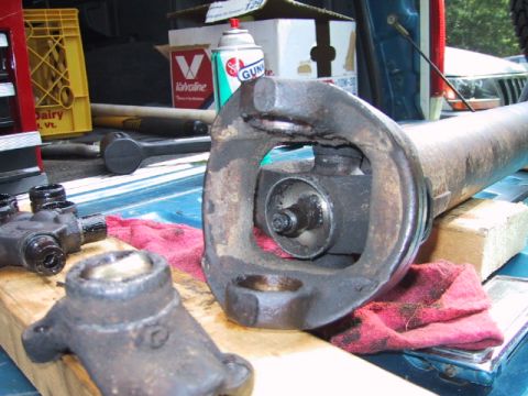 1988 Ford Bronco - Close-up view of a driveshaft universal joint, with shop rags and tools visible in the background.