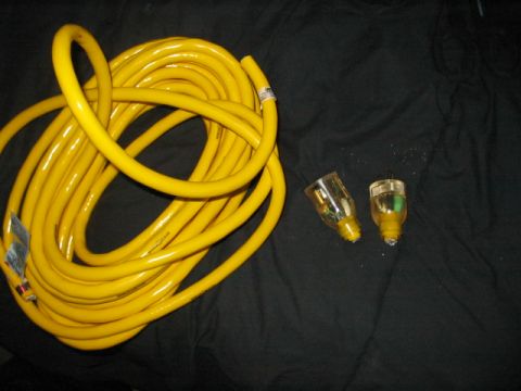 1991 Ford Bronco - A coiled yellow extension cord and two plugs are shown against a dark background.