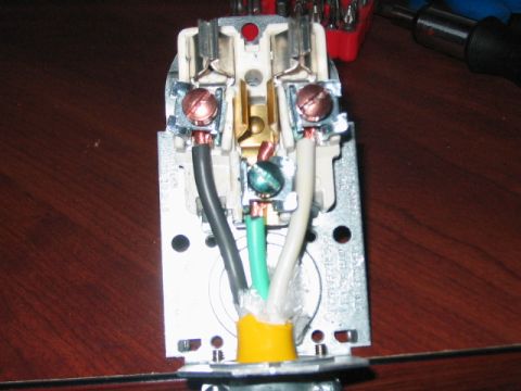 1991 Ford Bronco - Close-up view of the internal wiring of an electrical plug, showing connections for power and ground.