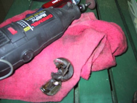 1988 Ford Bronco - A Dremel Multi-Pro rotary tool rests on a pink cloth next to a broken metal part.
