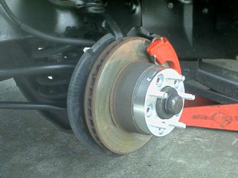 1976 Ford Ranchero - The rear brake assembly of a vehicle, showing the rotor, caliper, and suspension components.