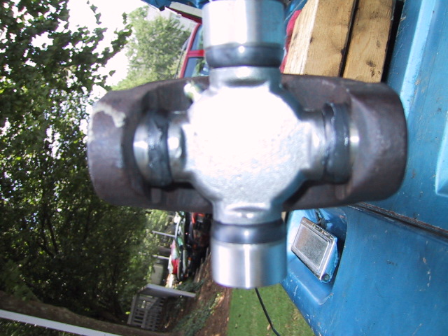 Close-up of a greased universal joint in a rusty driveshaft yoke
