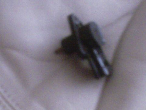 1995 Ford Probe - A close-up view of a dark-colored automotive sensor is shown against a light, textured background.