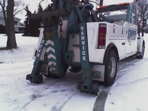1992 Ford Bronco - A tow truck is parked on a snowy road, with visible service markings.