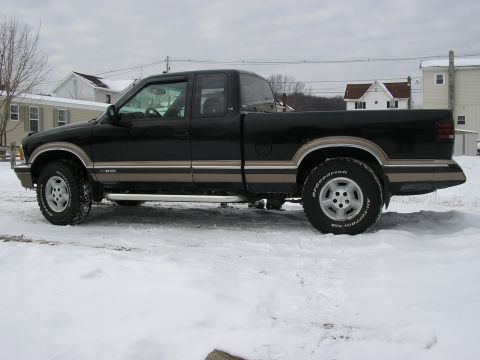 1994 Ford Probe - This black pickup truck with tan trim is parked on a snowy surface.