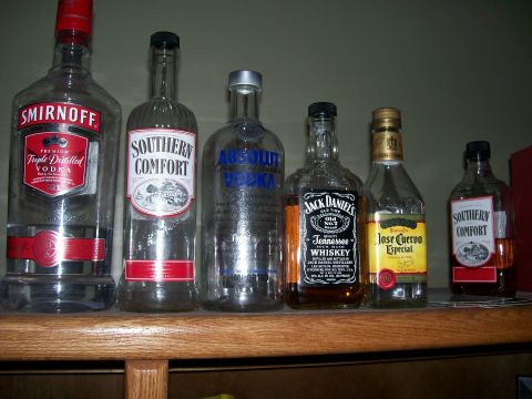 1996 Ford Bronco - A collection of various liquor bottles are lined up on a wooden shelf.