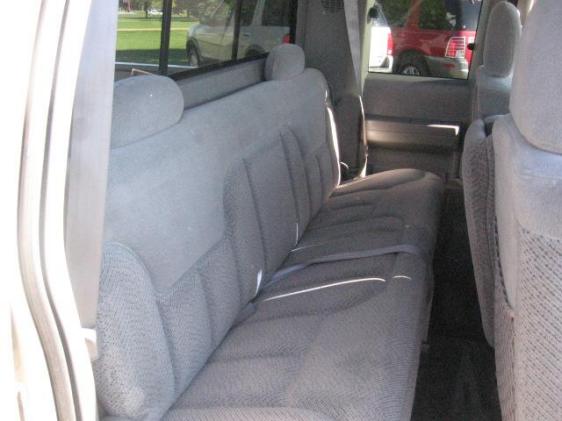 Gray cloth rear bench seat inside an extended cab pickup, viewed through the open door