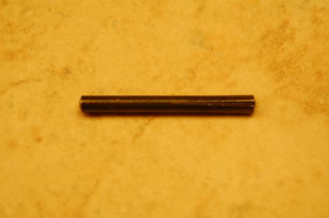 1993 Ford Bronco - A close-up shot of a small metal pin against a textured yellow background, with a website address visible.