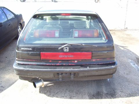 1993 Mazda MX-6 - This black Honda Civic hatchback displays its rear end, a distinctive red taillight strip and 'CIVIC' badging.