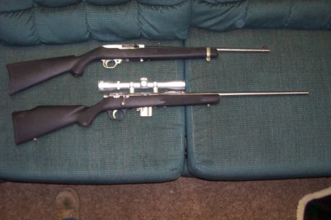 1994 Ford F-150 - Two rifles are placed on a green couch. One rifle has a scope mounted on top.