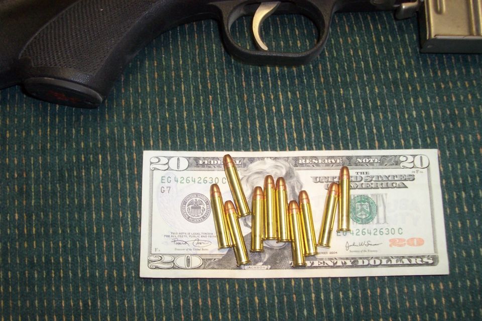 Gun and ammunition on a twenty-dollar bill