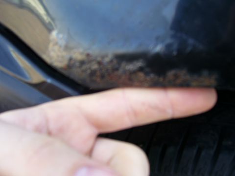 1993 Mazda MX-6 - Rust is visible on the lower edge of a car's body panel, near the tire.
