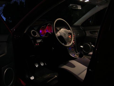 2007 Mazda 3 - The interior of a Mazda 3 is illuminated by its dashboard lights at night.