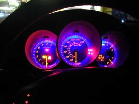 2007 Mazda 3 - The illuminated dashboard gauges of a car at night show the odometer reading 152.0 and 161.