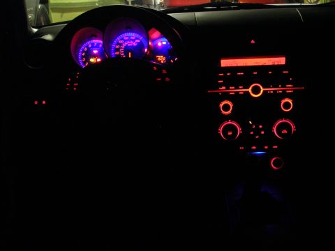 2007 Mazda 3 - The illuminated dashboard and center console of a 2007 Mazda 3 at night.