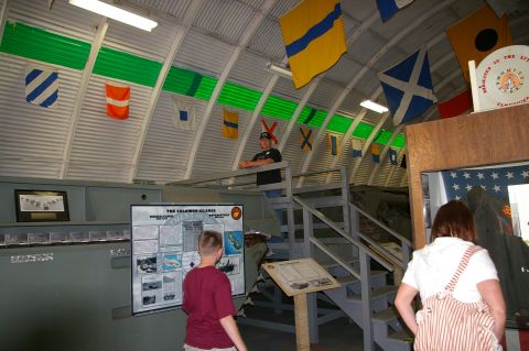1986 Ford Bronco - Interior view of a museum exhibit hall decorated with various nautical flags and historical displays.