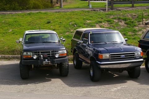 1986 Ford Bronco - Two Ford Broncos parked together. The one on the right appears to be a 1987 model.