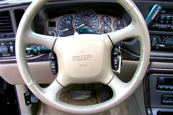 GMC steering wheel and dashboard with gauges visible. The album claims 1997 Ford Taurus, but this is a GMC interior