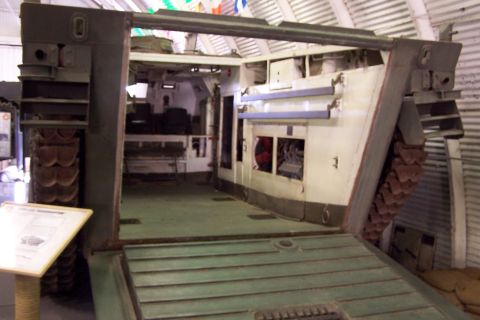 1990 Ford Bronco - The open rear ramp of an armored personnel carrier reveals its interior, including seating and mechanical components.