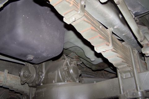 1990 Ford Bronco - A close-up view of the undercarriage of a vehicle, revealing its suspension and fuel tank components.