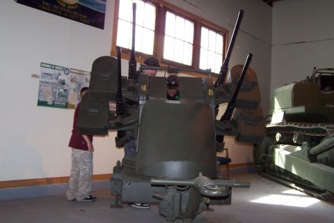1990 Ford Bronco - A museum display features an anti-aircraft gun mount and a tracked vehicle.
