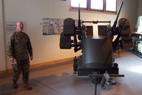 1990 Ford Bronco - A military museum displays a mounted gun system with a Marine standing nearby.
