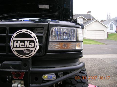 1996 Ford Bronco - Close-up of the front grille and headlights of a black SUV, a prominent Hella auxiliary light.