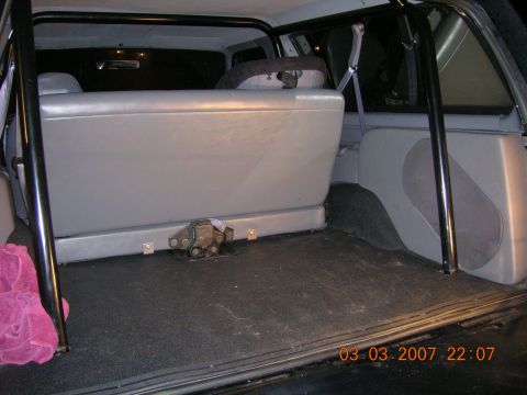 1996 Ford Bronco - The interior of a vehicle is shown, a roll cage and rear seating.