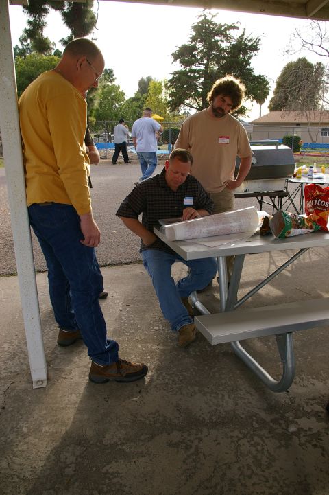 1986 Ford Bronco - People interacting around a picnic table at an outdoor gathering, with a grill visible in the background.