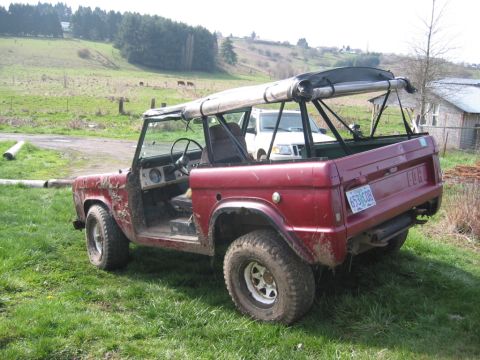 1968 Ford Bronco - This red 1968 Ford Bronco is seen from a 3q-front angle with its soft top removed, revealing its interior and the license plate 653 GOB.