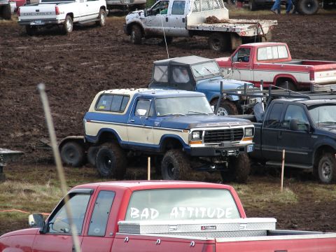 1996 Ford Bronco - A modified Ford Bronco sits in the mud at an event with other trucks.