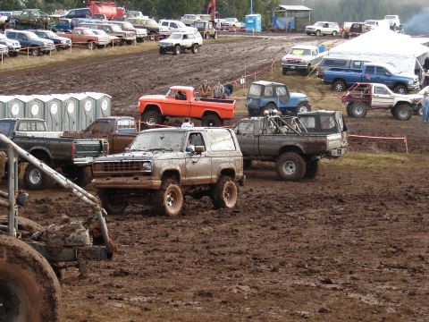 1996 Ford Bronco - Several off-road vehicles are stuck in the mud at a mud bog event.