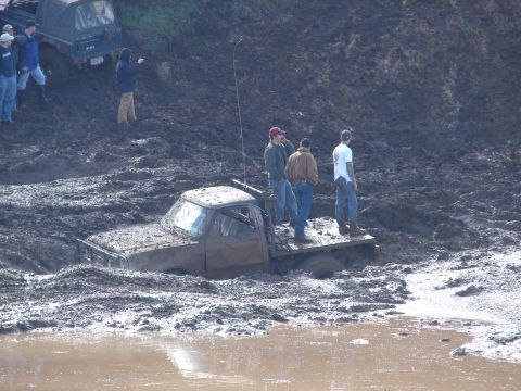 1996 Ford Bronco - Mud bogging event shows a truck submerged in thick mud with onlookers.
