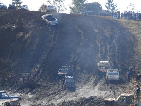 1996 Ford Bronco - Off-road vehicles navigate a challenging muddy terrain during an event.