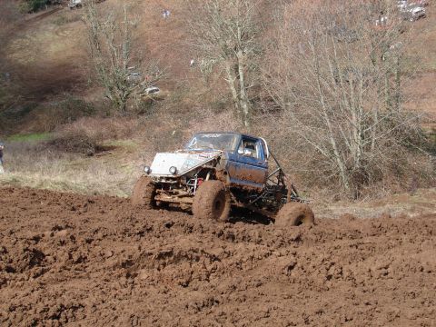 1996 Ford Bronco - This heavily modified off-road vehicle is deep in the mud during an event.