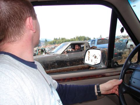 1996 Ford Bronco - A driver peers out of a mud-covered 1996 Ford Bronco during a mudfest event.