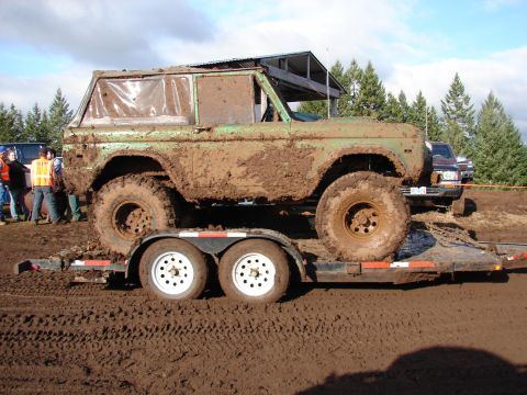 1996 Ford Bronco - Muddy 1978 Ford Bronco loaded onto a trailer at an off-road event.