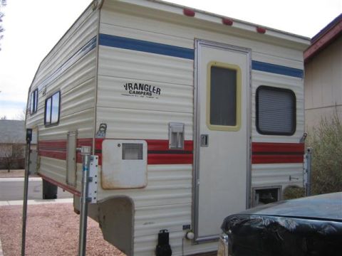 1999 Ford F-250 - This camper, labeled 'Wrangler Campers', is shown from the side, partially obscuring a vehicle in the foreground.