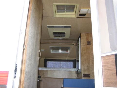 1999 Ford F-250 - Interior view of a camper van with a bed and air conditioning unit visible.