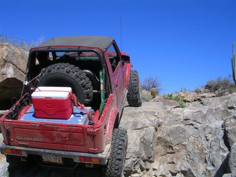 1987 Suzuki Samurai - This Suzuki Samurai is navigating a rocky trail under a clear blue sky.