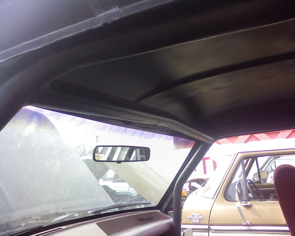 Interior view of a roll cage in a vehicle, with another vehicle visible through the windshield